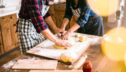 Authentic cooking at home: Authentic couple cooking at home, making pasta from scratch. You can see flour on their aprons