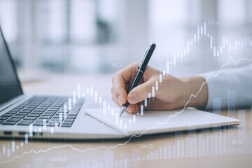 Financial Analyst Taking Notes with Laptop Displaying Stock Market Chart Overlay, Business Data Analysis