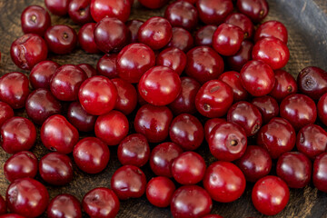 Fresh Red Bush Cherries Spread Out on Rustic Wooden Surface