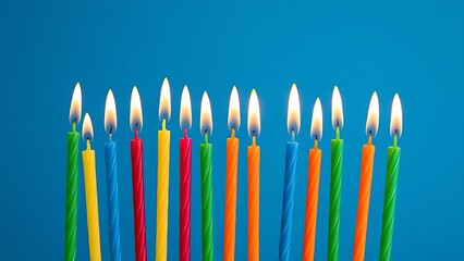 A row of colorful birthday candles with bright flames against a deep blue backdrop.