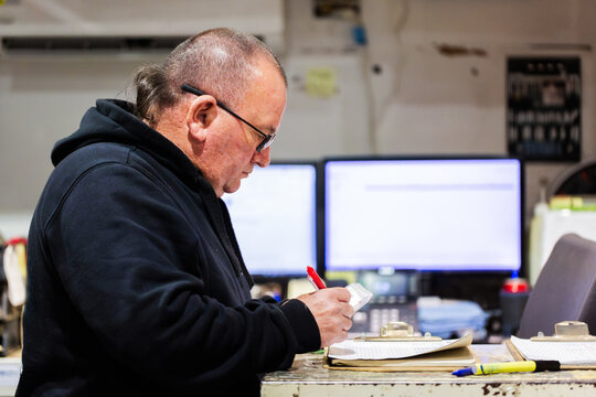 Parts man working in mechanics workshop storage room for fleet vehicle repair spare parts