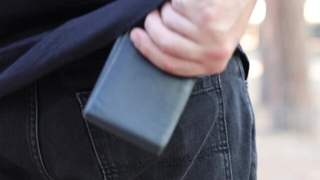 man pulling wallet out of back pocket