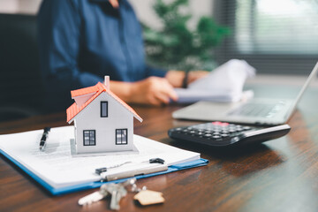 Female hand holds small miniature toy house, symbolizing woman dream of moving into her own home-real estate concept represents property investment, mortgage planning, insurance for secure future.