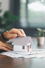 House model placed beside money coins illustrates concept of saving and financial planning for buying home, highlighting investment, mortgage options, home loans, refinancing, smart finance strategies