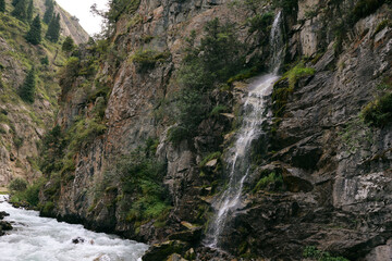 a waterfall flows down the rocks into a mountain river