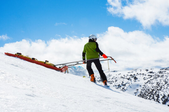 Ski rescue skiing down mountain with stretcher