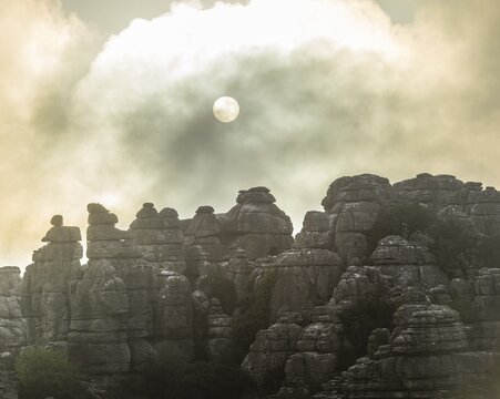 Bizarre limestone rock formations with the sun and fog, El Torcal Nature Reserve, Antequera, Andalusia, Spain