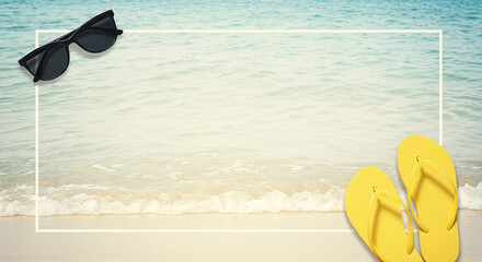 Bright yellow flip flops and sunglasses on a sandy beach near calm ocean waters