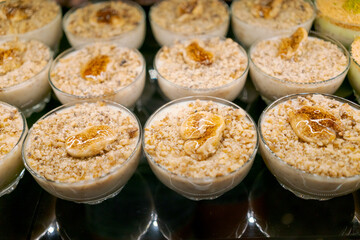 Row of small bowls filled with a dessert made with nuts and bananas