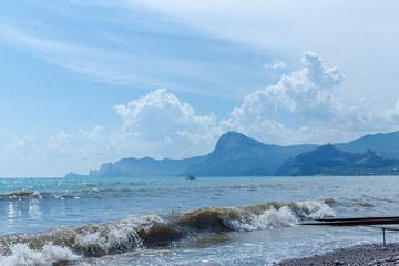 Obraz premium Boat is in the ocean near a rocky shore