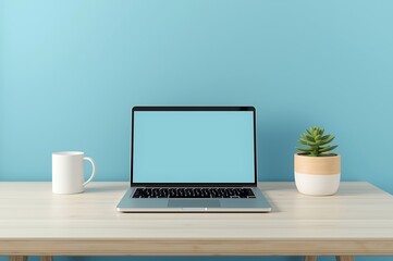 Fototapeta premium Modern home office setup featuring an open laptop white mug and small potted plant against a blue wall