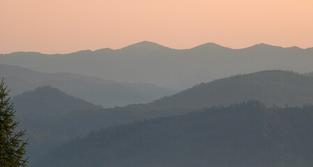 A breathtaking view of misty mountains at dawn, with layers of fog and forest, perfect for travel,...