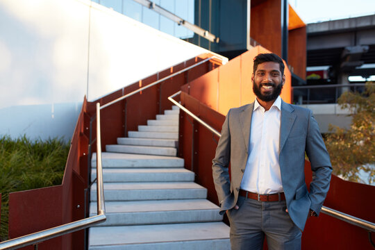 Indian businessman with open collar cheerful outdoors in city