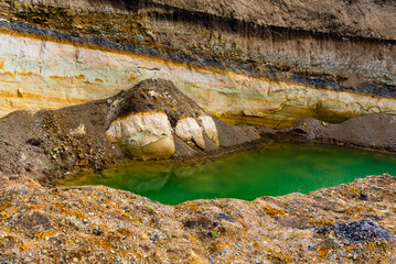 Sand quarry filled with water reflecting the cloudy sky, creating an industrial yet natural...