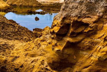 Sand quarry filled with water reflecting the cloudy sky, creating an industrial yet natural...