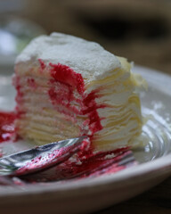 Delicious Crepe Cake on a White Plate with Berry Sauce.