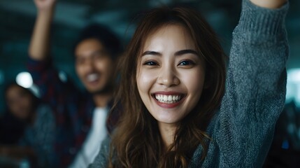 Joyful Asian startup team celebrating a small success in the office