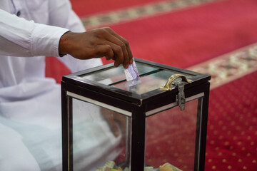 A person who donates money to a mosque donation box