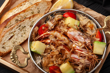 Delicious seafood dish served with fresh bread and garnished with vegetables and lemon in a cozy setting