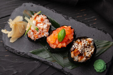 Fresh sushi assortment with crab, salmon, and eel on a stone platter at a Japanese restaurant