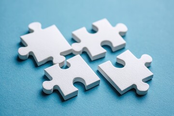 Obraz premium Four white puzzle pieces on a light-blue surface