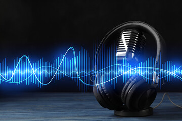 Headphones, microphone and sound waves against black background