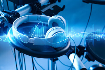 Headphones, electronic drum kit and sound waves, toned in blue