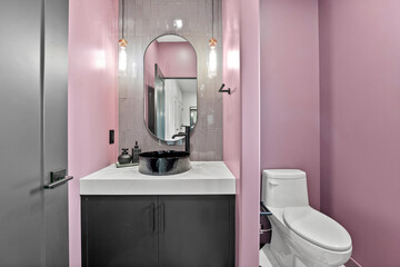 Bathroom with a pink wall and a black sink