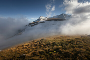Dramatic mountain landscape shrouded in clouds during early morning light in a serene high-altitude location