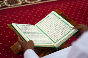 Closeup, A Muslim is reading the holy book of the Koran in the mosque