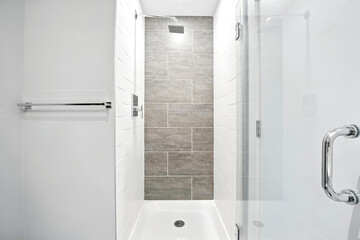 White bathroom with a shower stall and a glass door