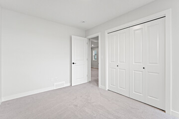 White bedroom with a white closet and a white door