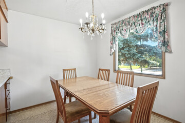 Wooden dining table with a chandelier hanging above it