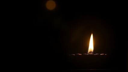 Golden diya glowing in darkness, symbolizing tradition and festive spirit in Indian culture.