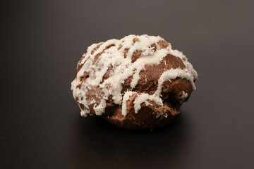 Profiteroles with coconut cream on a black background.