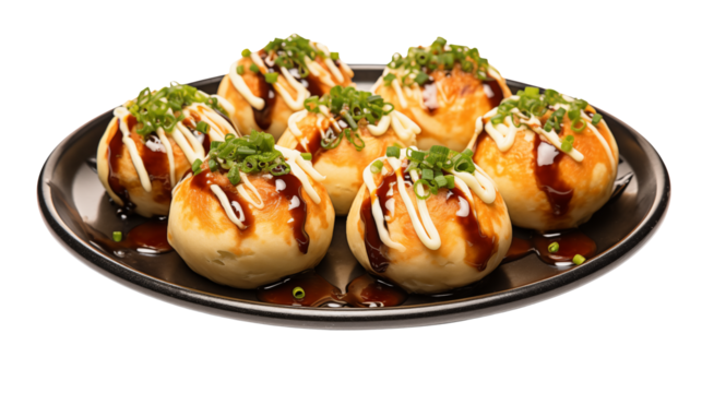 A close up shot of takoyaki balls on a black plate drizzled with sauce and topped with green onions