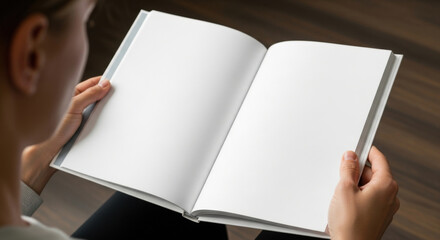 Person holding open white blank book mockup, education concept of new beginning, imagination design publishing, World Book Day, International Literacy Day. Over the shoulder view