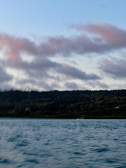 Small Boat on Calm Water with a Forested Island in the Distance

