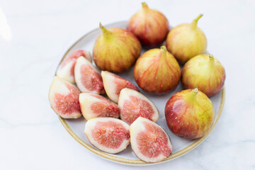 A vibrant plate of fresh figs, showcasing their rich colors and fruity halves, perfect for healthy...