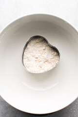 overhead view of All purpose flour in a measuring cup, top view of baking flour