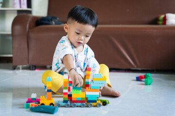 Fototapeta premium Child Playing with Colorful Building Blocks Indoors
