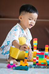 Fototapeta premium Child Playing with Colorful Building Blocks Indoors
