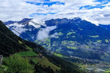 View from Hochmuth mountain station with panorama of summits Hirzer and Ifinger in the clouds in South Tyrol, Italy