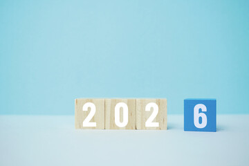 Wooden blocks displaying the year 2026 against a minimal blue backdrop