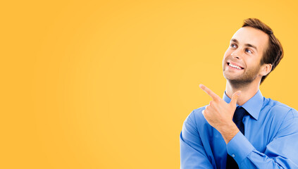 Portrait image - happy smile confident business man in blue shirt and tie point show upward index...