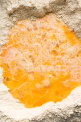 overhead view of eggs and flour in a mixing bowl, process of making Nigerian chin-chin