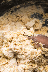 Nigerian Chin chin dough in a black mixing bowl, Raw chin-chinbeing mixed, process of making chin...
