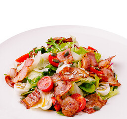 Fresh salad with bacon, vegetables, and seeds served on a white plate