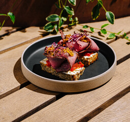 Two open-faced sandwiches are served on a round plate