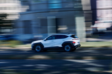 White SUV driving in the city with motion blur, urban transport and speed concept